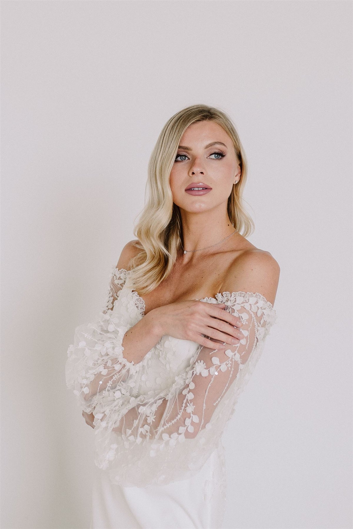 Off the shoulder modern wedding dress. Crepe, 3D lace. Fit and flare, long sleeves. Custom made by Catherine Langlois, Toronto bridal studio