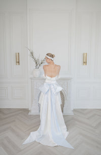 High low short wedding dress with a big bridal bow. White and blue satin. Corset, off the shoulder cap sleeves. Custom made in Toronto by Catherine Langlois.