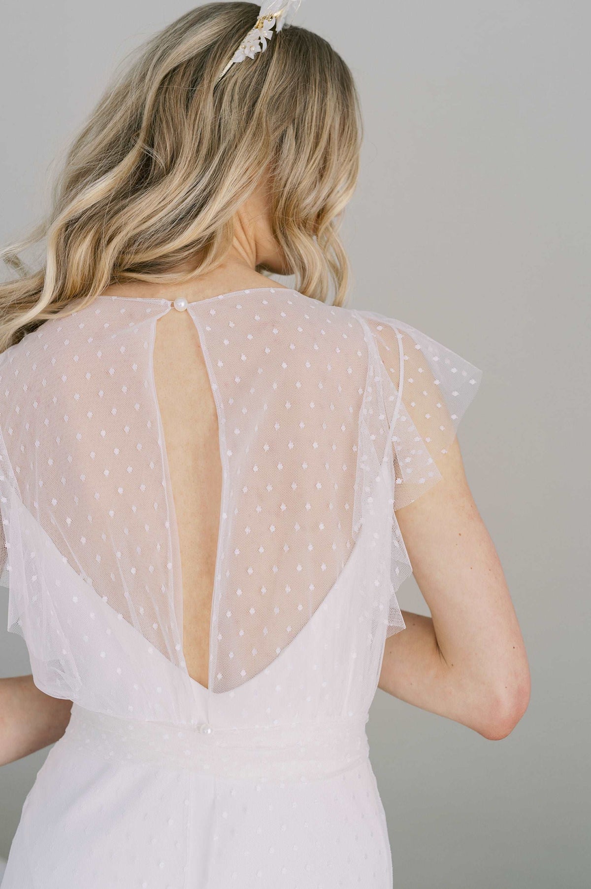 Whimsical and romantic dotted tulle wedding dress. Nostalgic ruffles cascade down the front and back.Shown with a simple slip dress lining. Designed by Catherine Langlois, Canada.