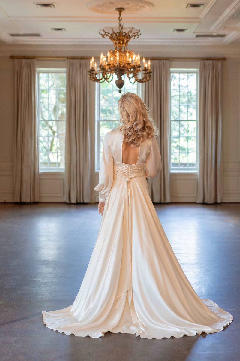 Canadian custom wedding dresses. Glamourous old Hollywood silk satin wedding dress. Shown in blush. Keyhole back, self tied sash and high neckline. Satin buttons. Designed by Catherine Langlois. Shop our Toronto bridal boutique.