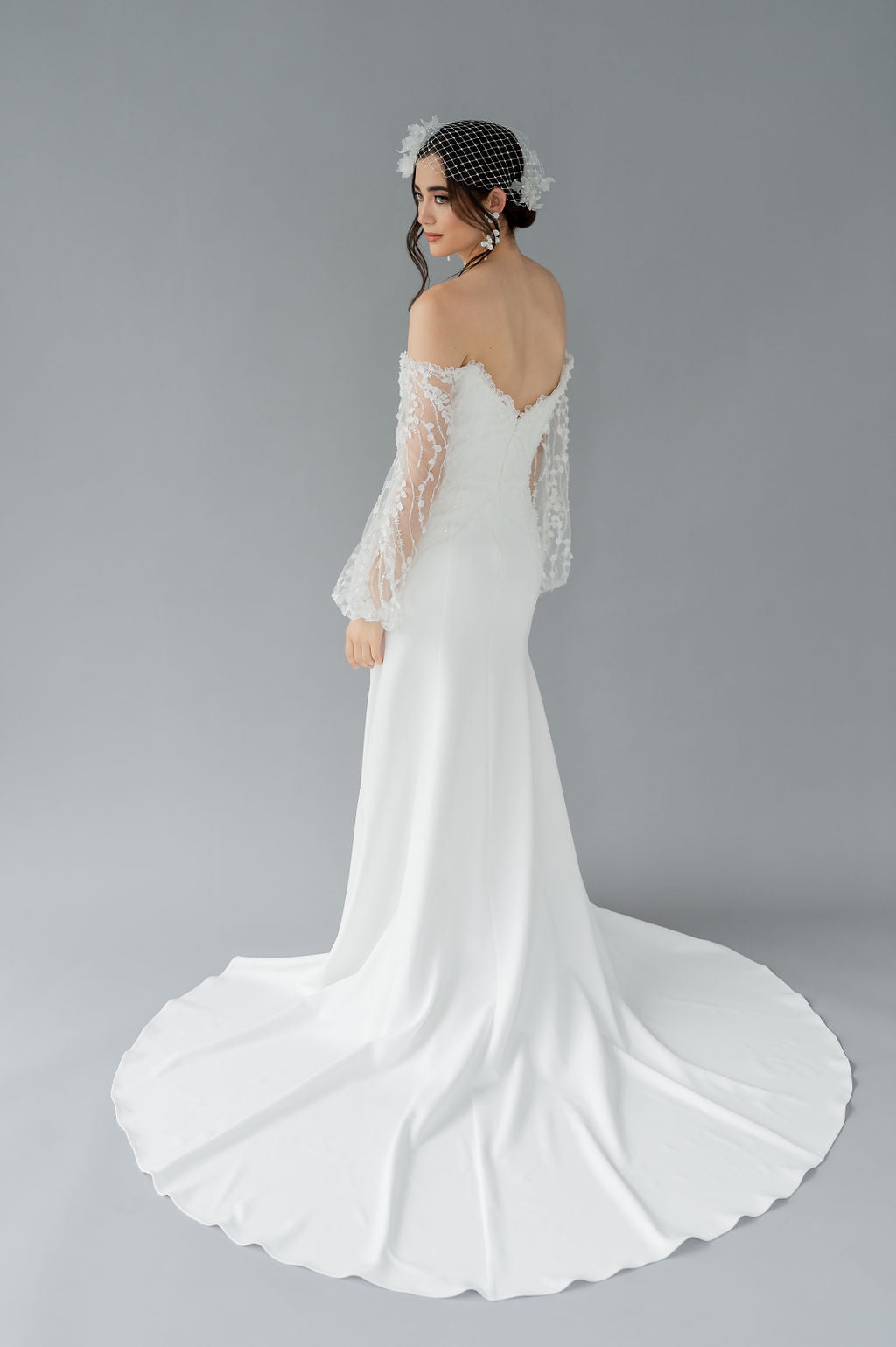 Modern fit and flare wedding dress with long 3D lace poet sleeves. Off the shloulder, crepe skirt. Designed and made in Canada by Catherine Langlois.