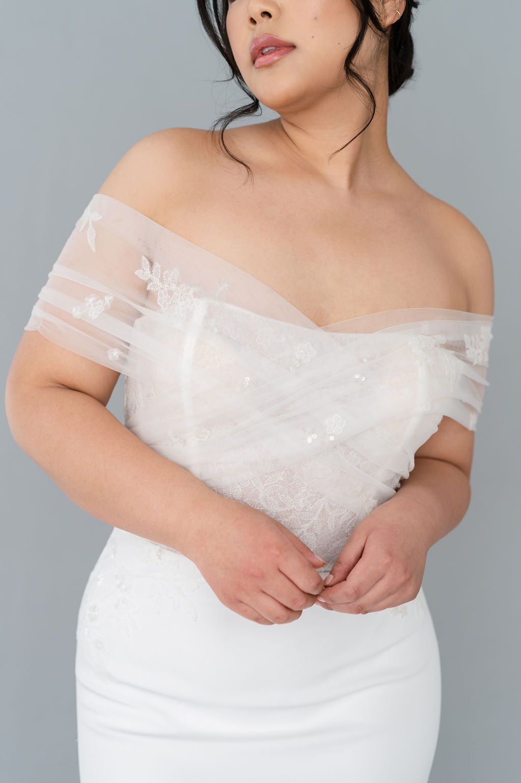 Romantic off the shoulder wedding dress by Catherine Langlois. Fit and flare silhouette accentuates the body in a modern intrepretation of delicate design. Inclusive size wedding dresses made in Canada.