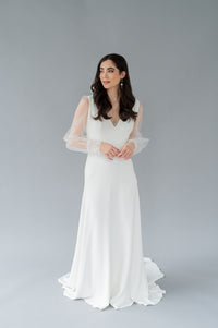 Simple crepe Aline wedding dress by Catherine Langlois. V neckline, long sheer tulle poet sleeves and pearl buttons with lace cuffs.