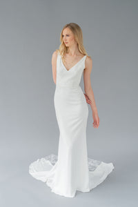 Simple v neck crepe wedding dress by Catherine Langlois. Leaf lace applique and train, fit and flare gown in stretch crepe. Handmade in Toronto, Canada.