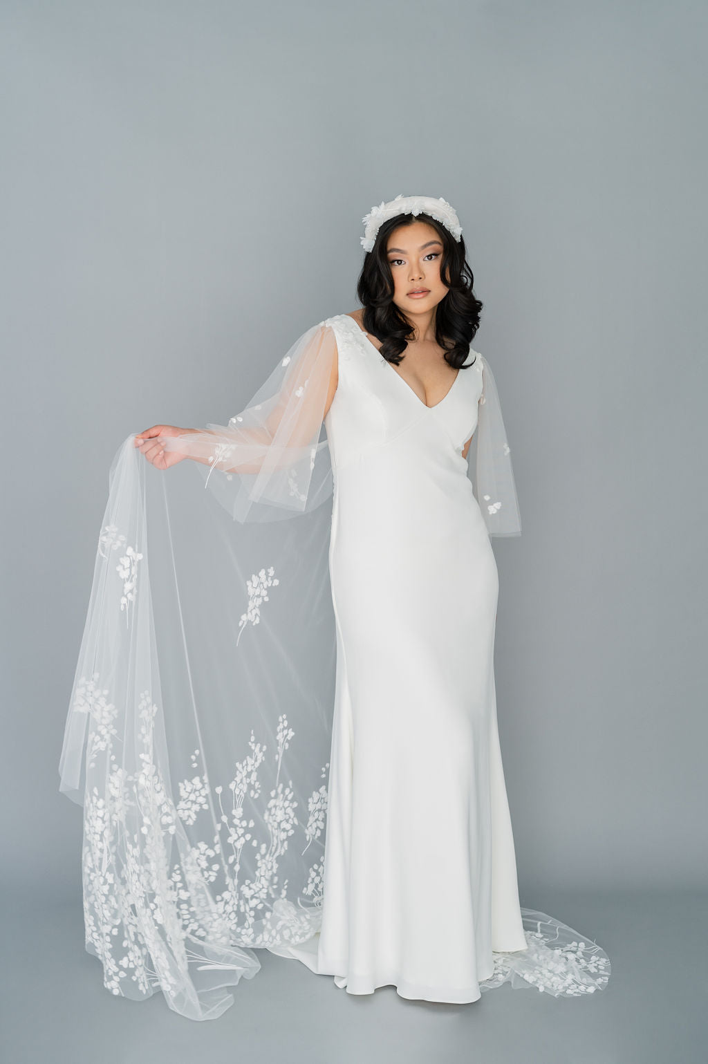 Romantic yet classic crepe and tulle wedding dress. Whimsical 3D applique with tulle flutter sleeves and train. Empire line and V neckline. Custom made in Toronto by Catherine Langlois.