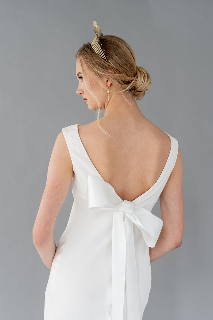 Elegant understated wedding dress by Catherine Langlois. Low v back, boat neckline. Satin bow detailing. Silk or Eco crepe.
