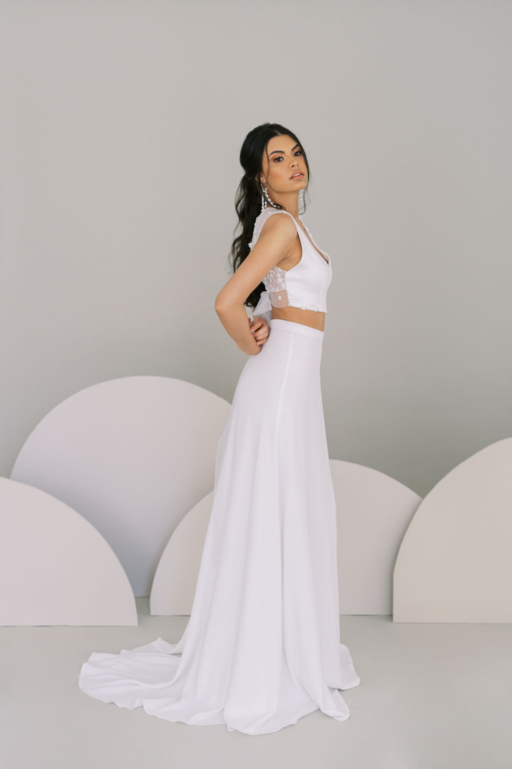 Chic whimsical bridal crop top worn with an A line skirt.. 3D lace at back, crepe front. Self tied tulle bow at the back. By Catherine Langlois, Toronto, Canada.